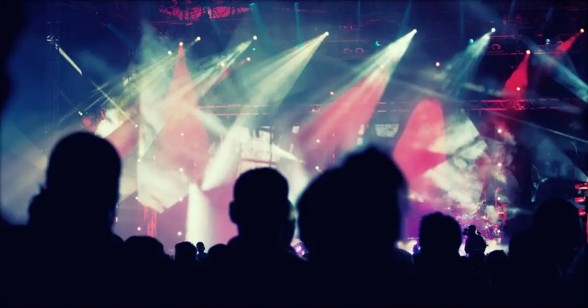 Cheering crowd in front of stage lights - retro photo – United Outcomes – United Outcomes Concert Venue with large attendance that is subject to the Protection of Premises Act 2025